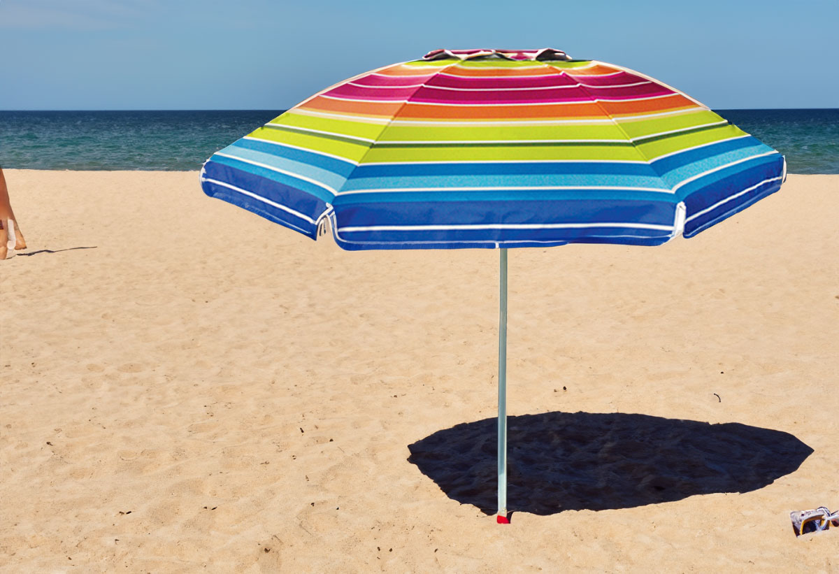 Η ομπρέλα τοποθετημένη στην παραλία την ώρα που προστατεύει το περιεχόμενό της από τις βλαβερές ακτίνες UV του ήλιου.